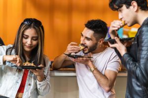 three latinos eating tacos in taqueria